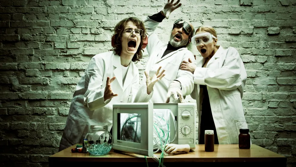 three crazy scientist experimenting with a microwave oven