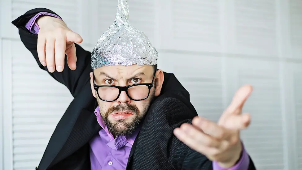 Man trying to communicate via thought while wearing a tin foil hat