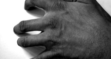 Angry man scrapes fingernails on desk