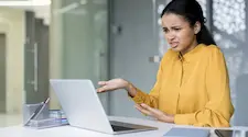 Confused woman sat in front of her laptop trying to understand what that image is for