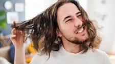 man running hand through his long hair