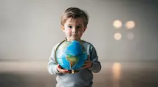 small boy holding a globe of the world in his hands