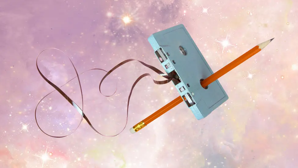 Unspooled cassette tape being fixed with a pencil floating on a galaxy 