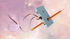 Unspooled cassette tape being fixed with a pencil floating on a galaxy background