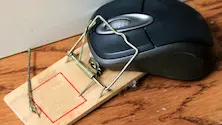 computer mouse trapped in a wooden mouse trap