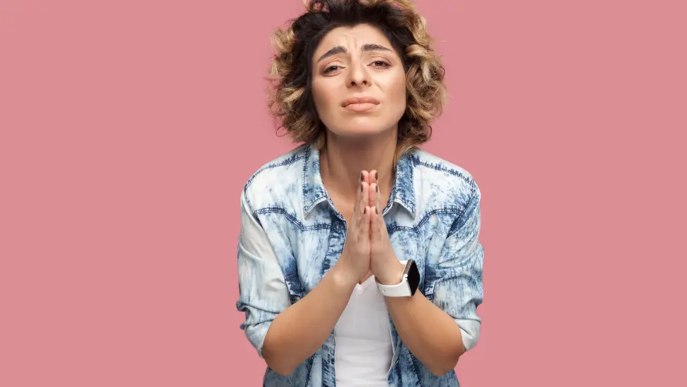 woman with hands clasped together like they are in prayer