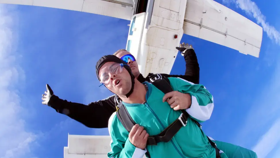 two people who have just jumped out ofa small plane for a tandem skydive