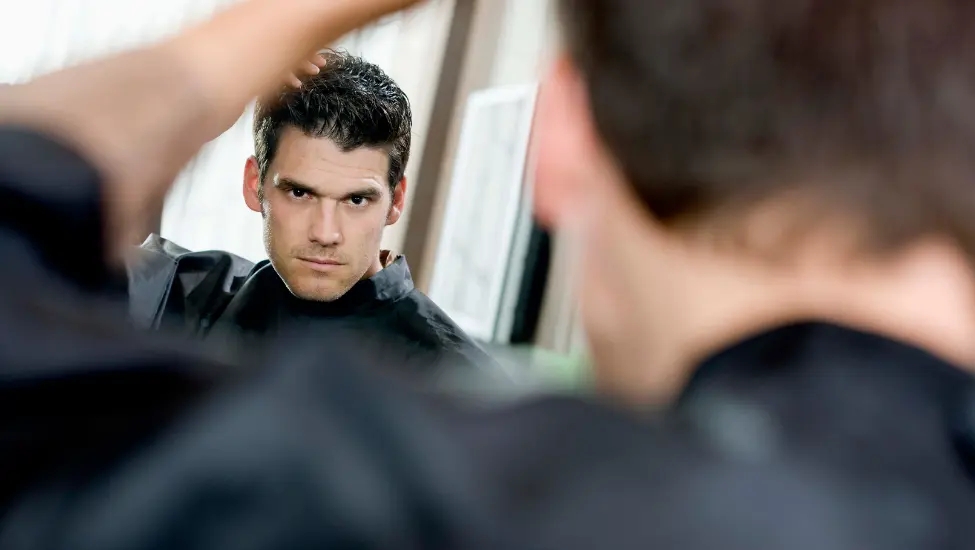 good looking man admiring himself in the mirror