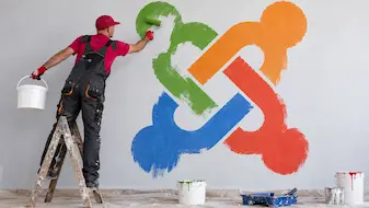 Man painting a large Joomla logo on a wall